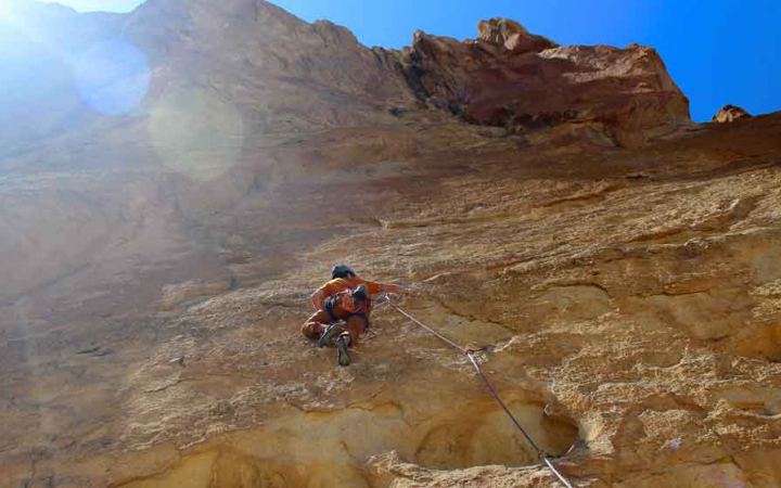 a person is high up on a rock face as they climb higher